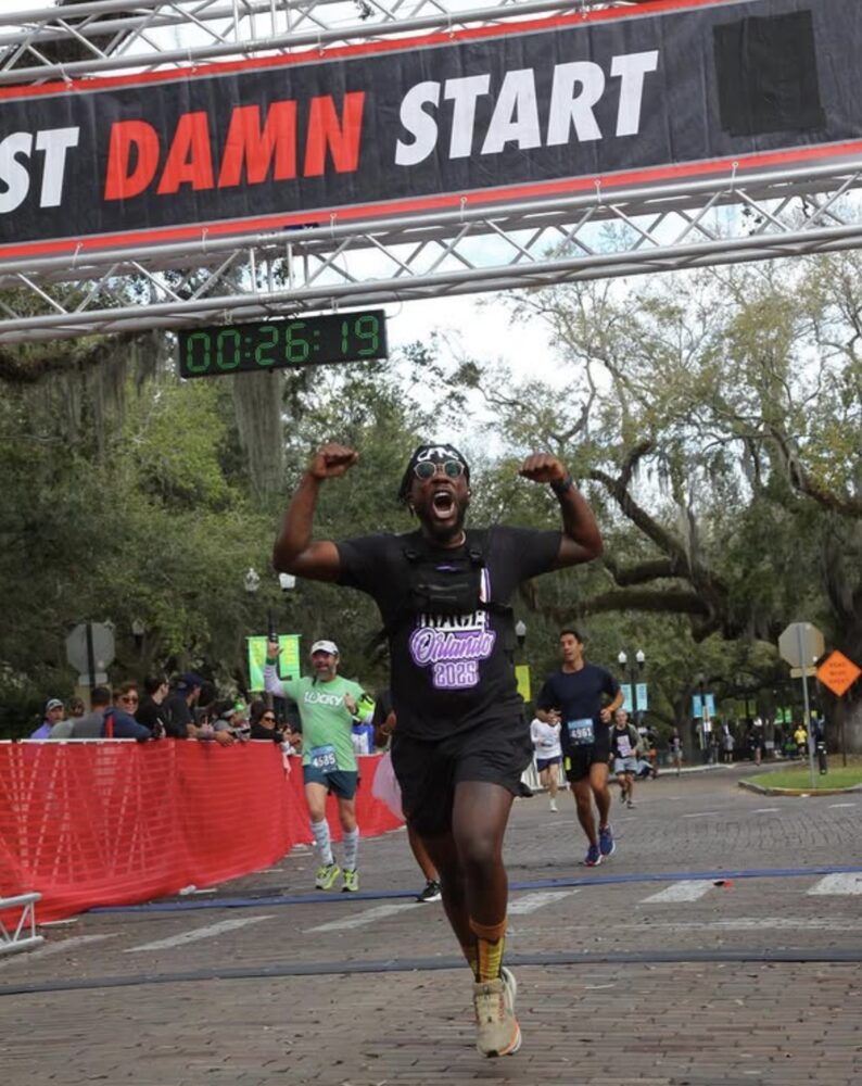 Philippe celebrating crossing a race finish line