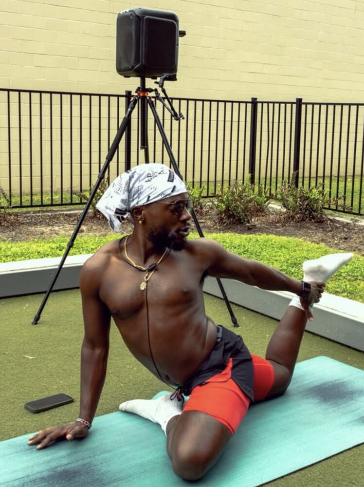 Philippe stretching on a mat outdoors